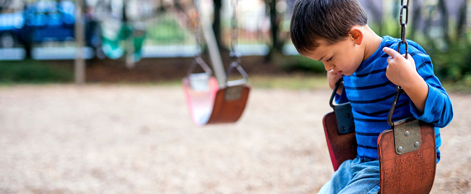 image of a child looking sad on a swing